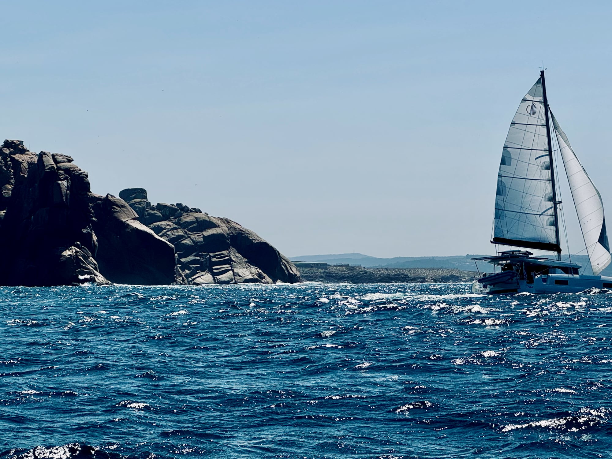 Catamaran navigiert durch die Felsen